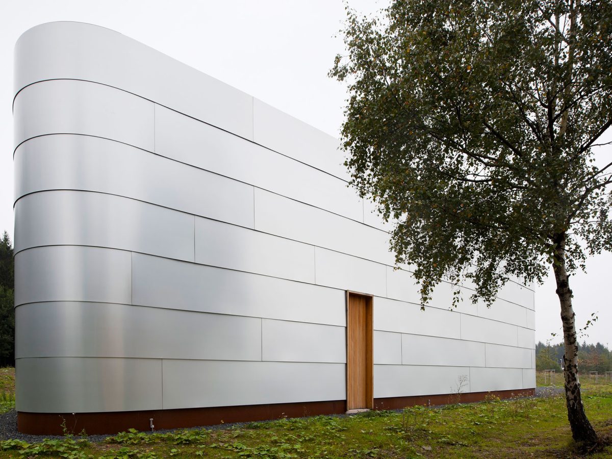 Schaulager-Architektur mit Aluminiumfassade, gerundeten Ecken, Holztür