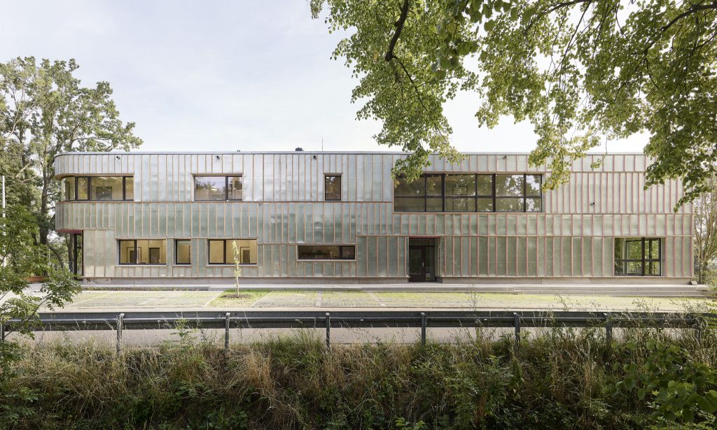 schillernde Blechfassade mit Fenstern und Türen