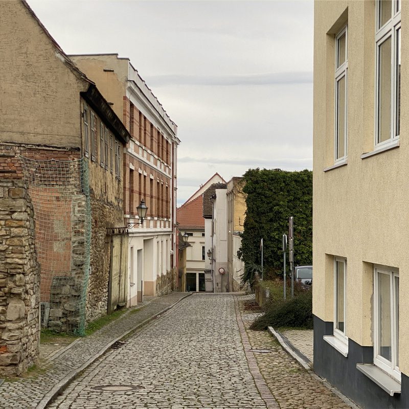 enge Straße mit Kopfsteinpflaster und historischen Gebäuden